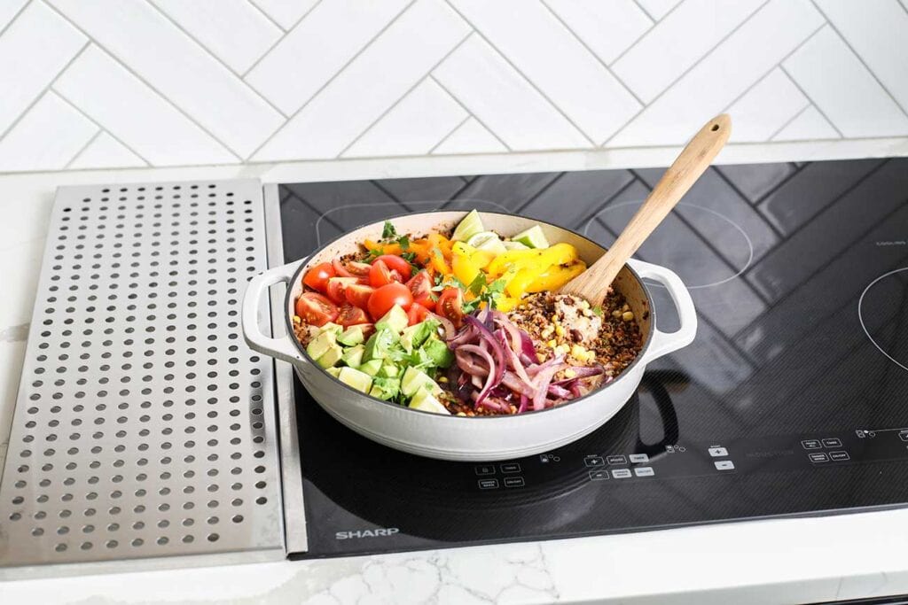 A quinoa dish covered with colorful veggies on the Sharp Induction Cooktop.