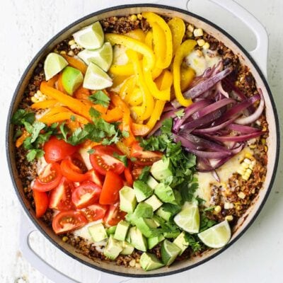 A pan of Mexican quinoa covered with a rainbow of vegetables.