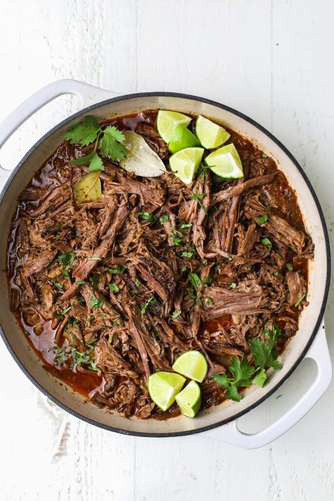 A pot of shredded beef mixed with a flavorful consome.
