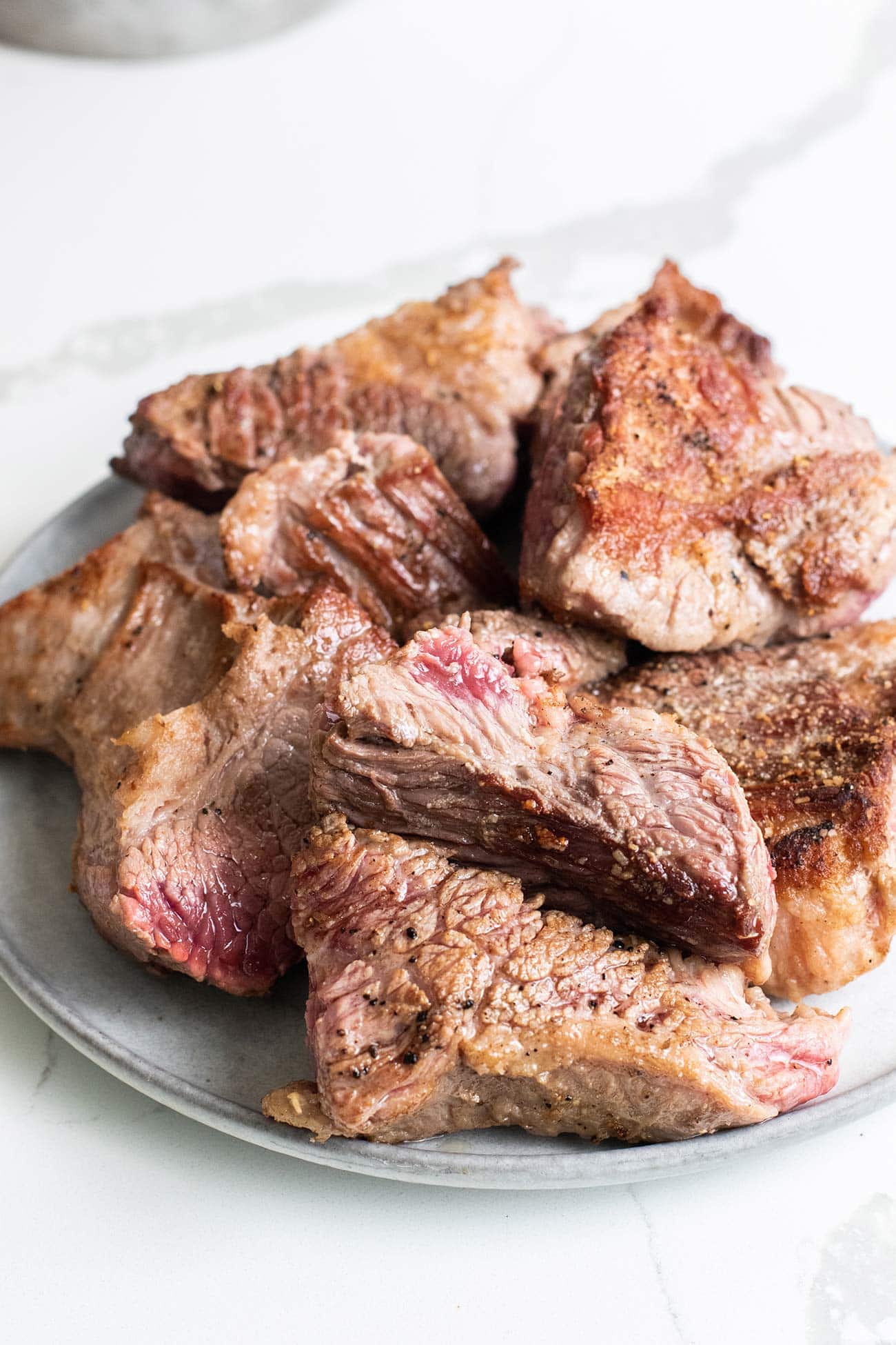 A browned chunks of beef set aside on a plate.