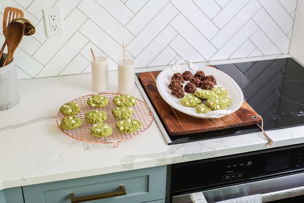 A platter of matcha cookies and no bake cookies sitting on a Sharp oven.