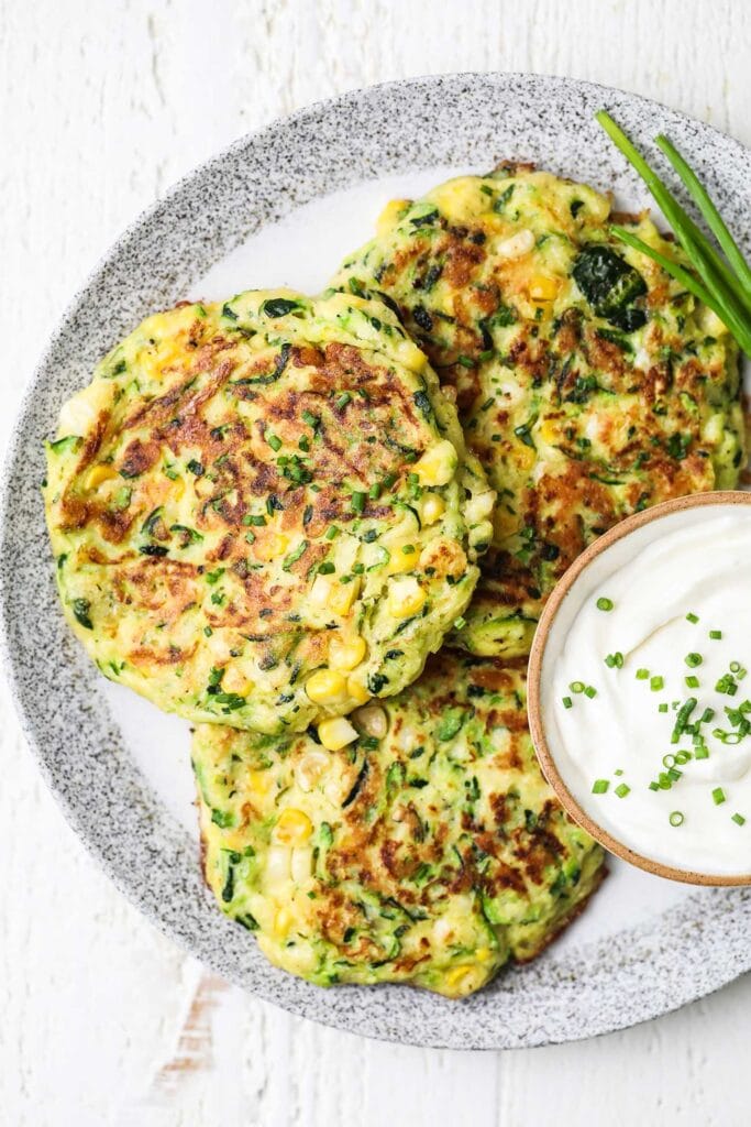 Crispy brown zucchini fritters served with sour cream.