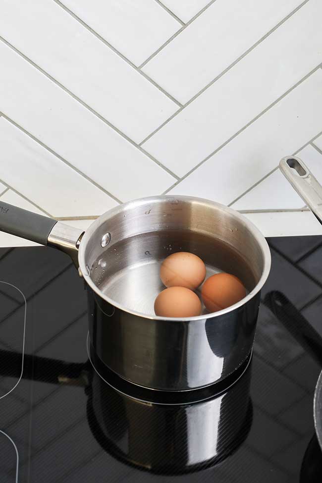 Eggs being boiled on a cooktop.