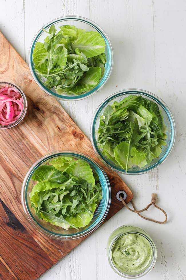 Lettuce and arugula in meal prep containers.