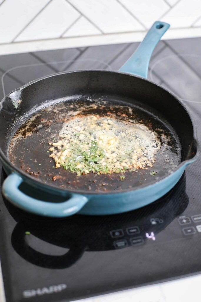 Butter, garlic and herbs shown browning in a skillet.