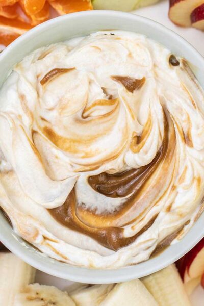 A close up look at a Greek yogurt fruit dip swirled with a sunbutter caramel sauce.