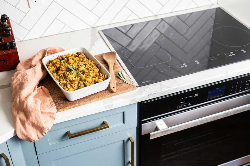 A baking dish with sausage stuffing shown next to the Sharp appliances.