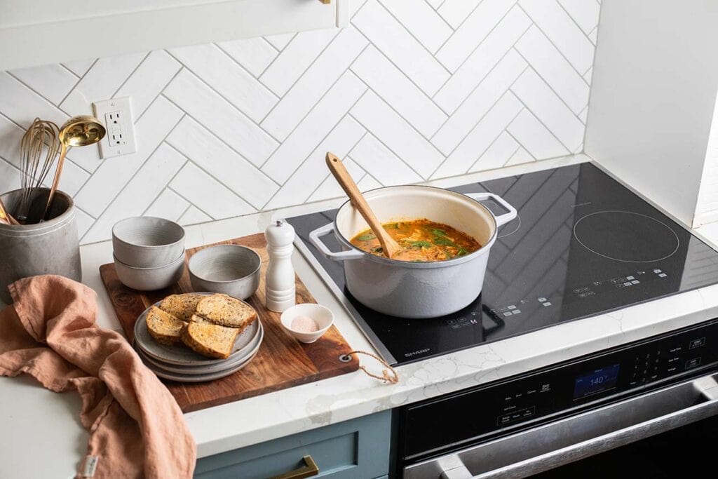 A sharp induction cooktop shown with a pot of turkey soup.
