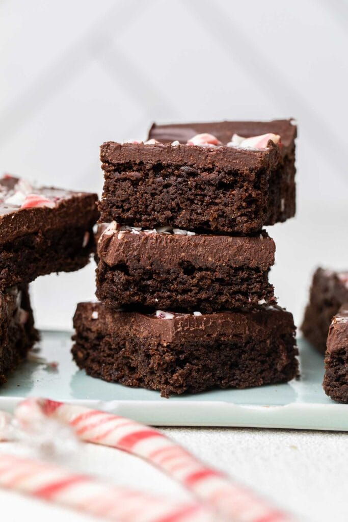 A stack of peppermint brownies showing the layer of chocolate ganache.