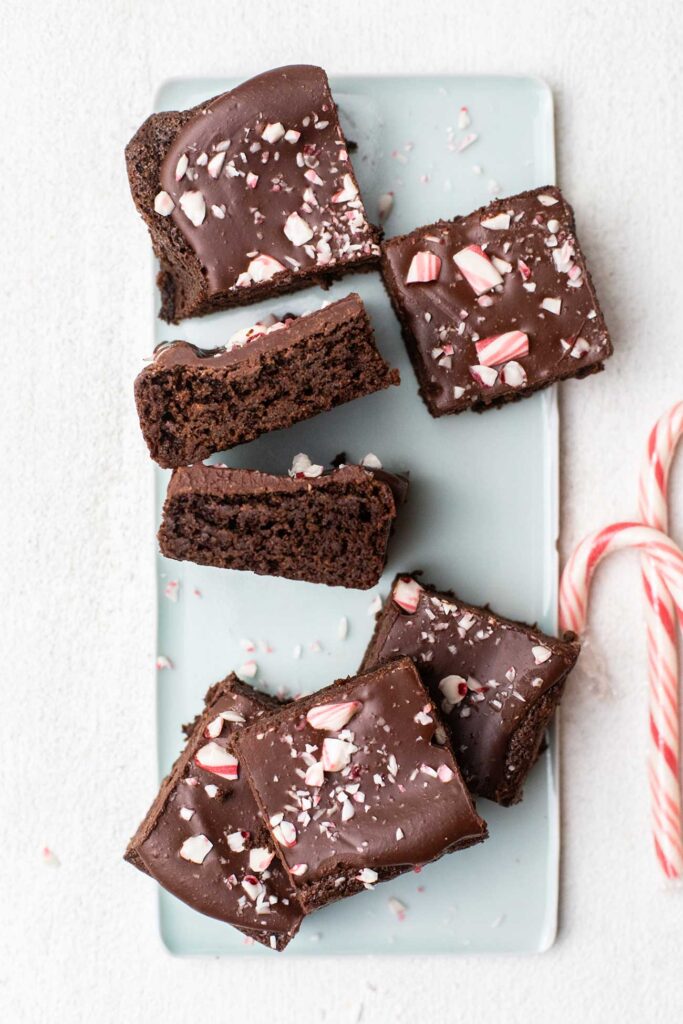 A platter of brownies topped with peppermint fudge and candy canes.
