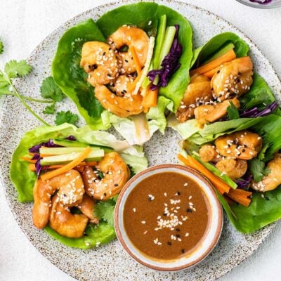 A plate showing lettuce wraps filled with spicy shrimp and crispy vegetables.