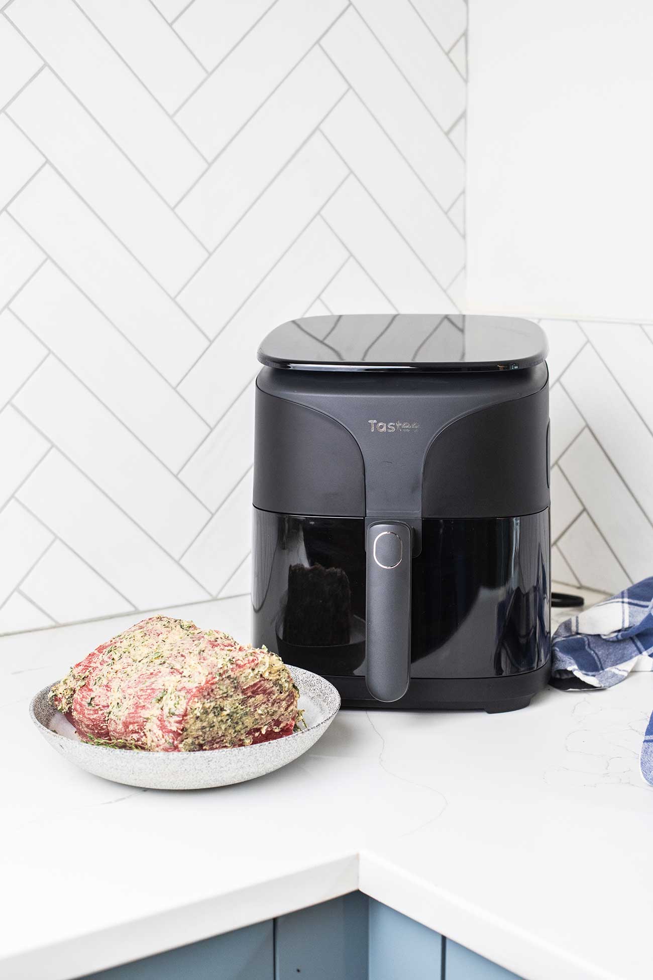 Tastee air fryer shown with a beef roast sitting in front of it.