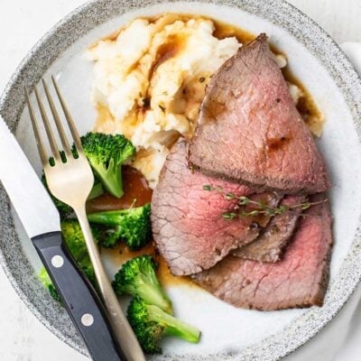 A plate shown with roast beef, mashed potatoes, and broccoli.
