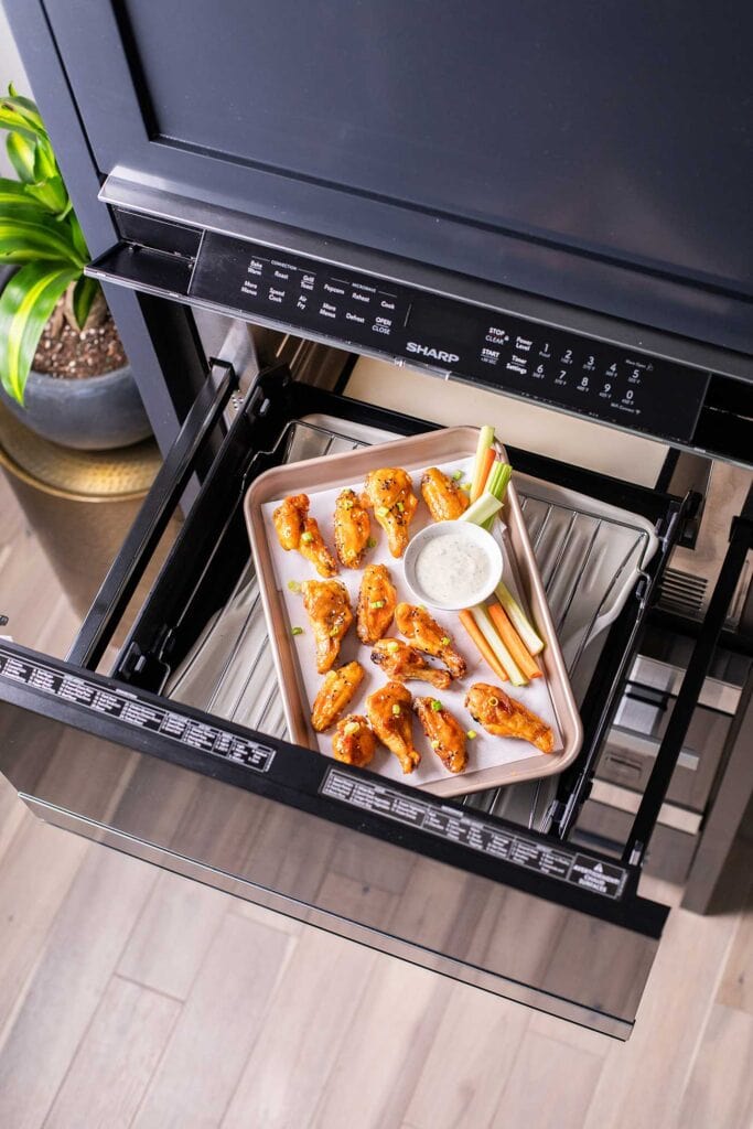 A pan of hot wings sitting inside the Sharp Convection Microwave Oven.