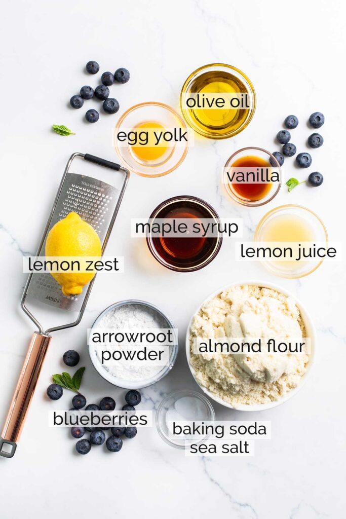 The ingredients needed to make lemon blueberry cookies shown with labels.