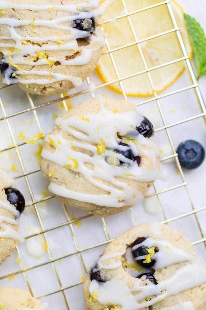 A close up look at lemon blueberry cookies with a drizzle of glaze.
