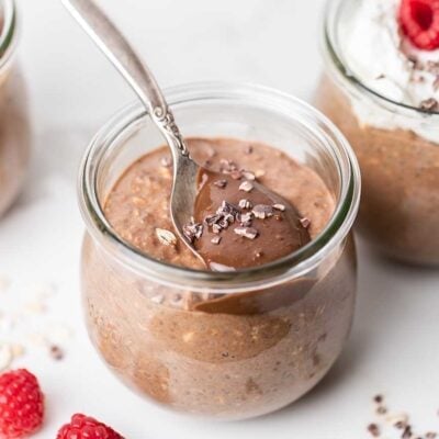 A jar of overnight oats shown with a spoonful of chocolate sunbutter on top.