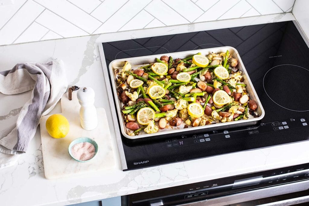 A sheet pan with roasted vegetables sitting on top of the Sharp Convection Oven.