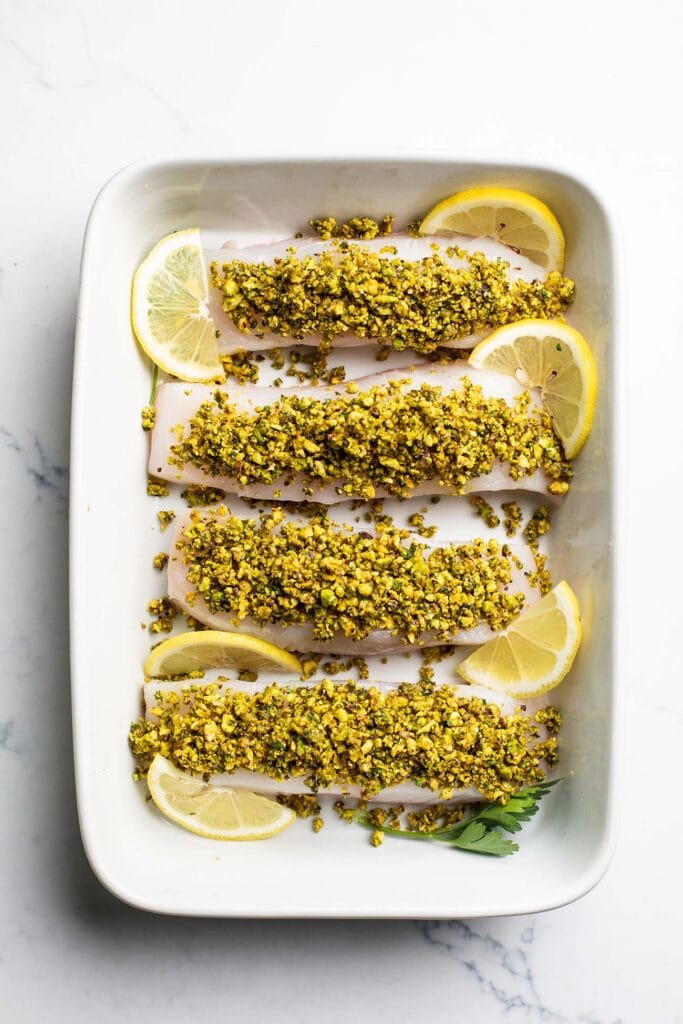 The pistachio topping shown pressed on to the tops of the halibut fillets, and a dish showing the baked fish with a lightly browned topping.