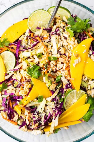 A large glass bowl filled with a colorful asian style cabbage salad.