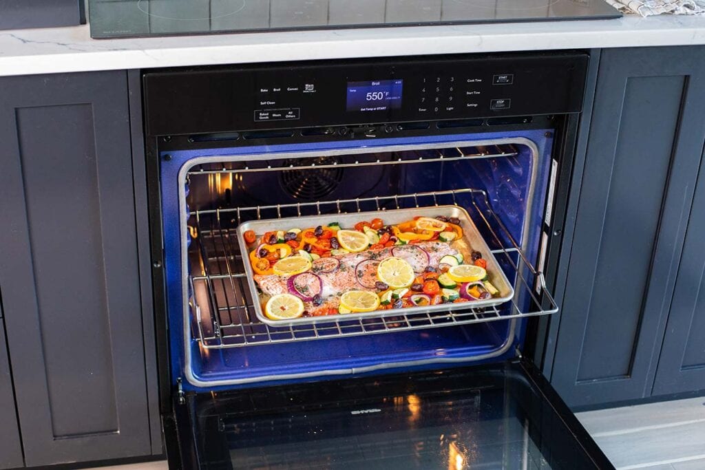 The Sharp European Convection Oven shown with a pan of baked salmon and vegetables.