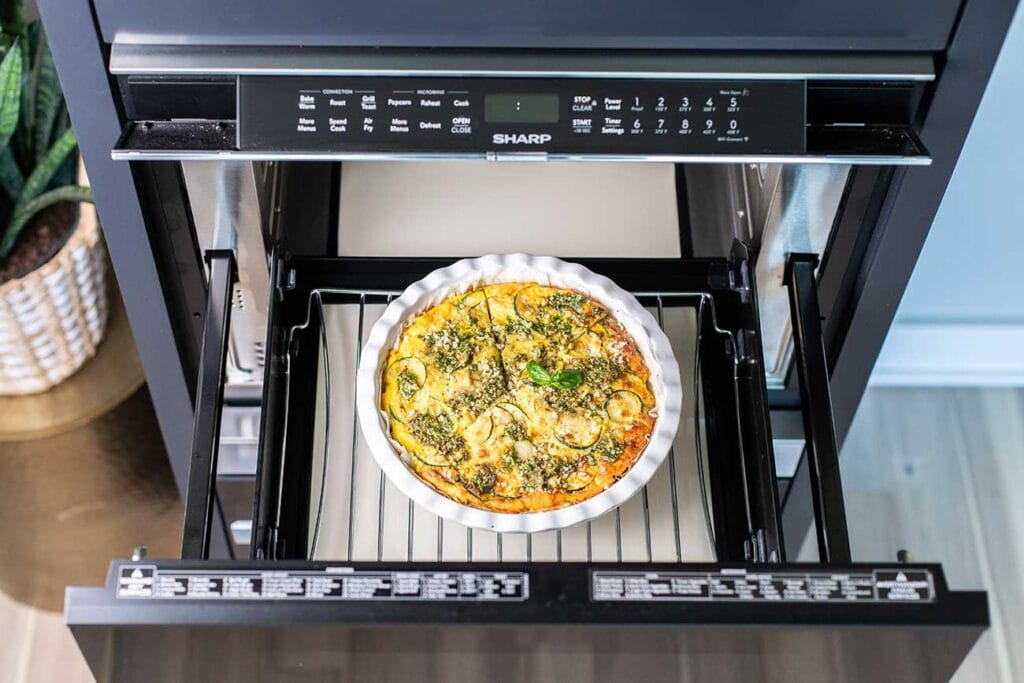 A crustless zucchini quiche shown sitting in the sharp microwave convection oven.