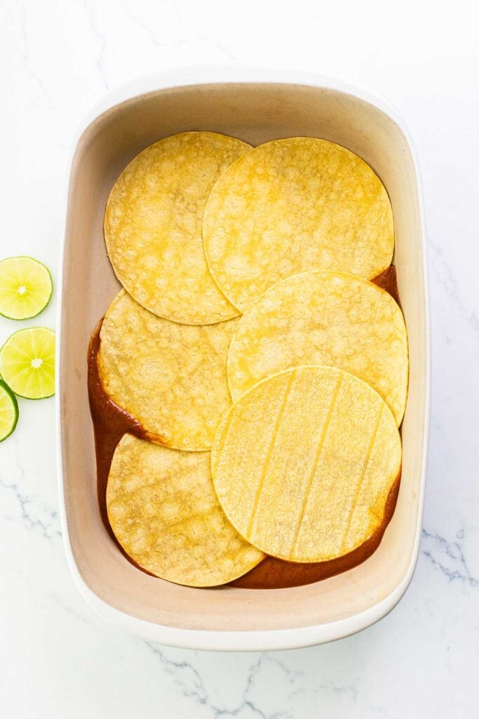 Step 4 shows adding enchilada sauce and a layer of tortillas to the bottom of a casserole pan.