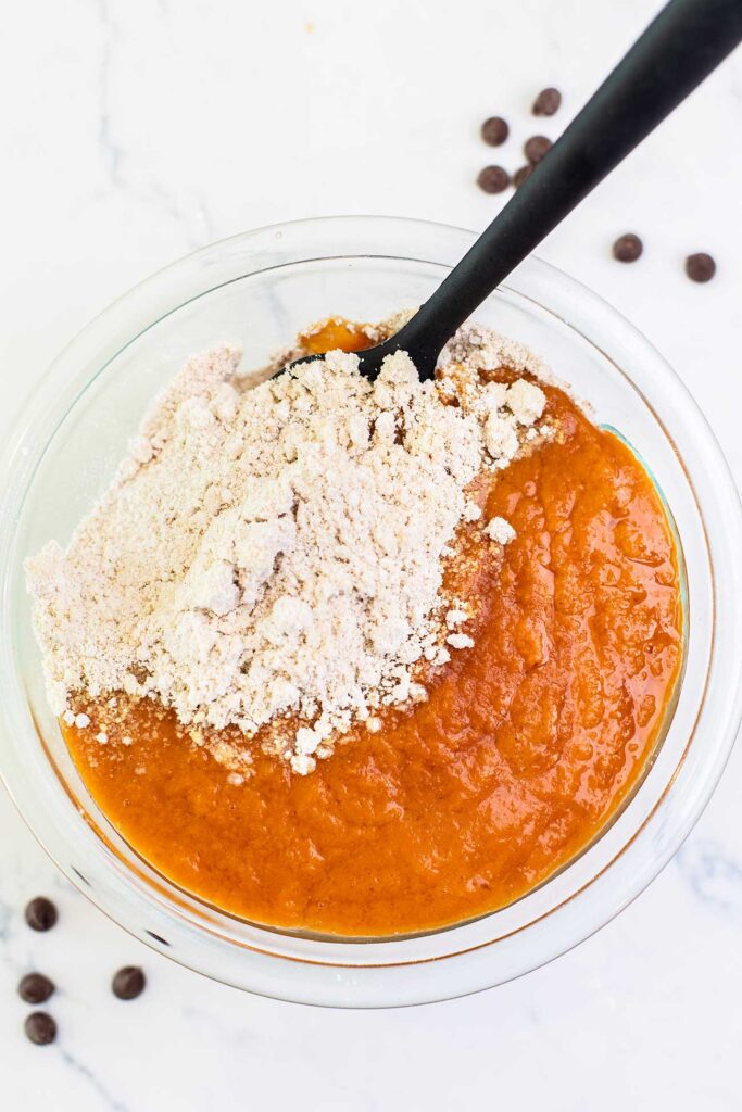 The dry ingredients being mixed into the bowl of wet ingredients.