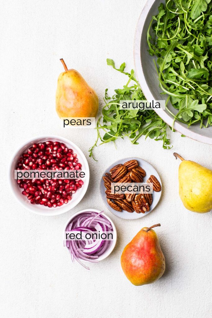 The ingredients in a pear and arugula salad.