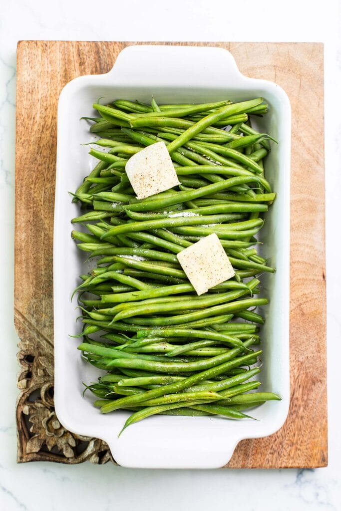 Step 1 shows seasoning the green beans with butter, salt and pepper, and steaming them.