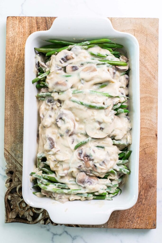 A casserole dish with steamed green beans tossed with a homemade cream of mushroom soup.