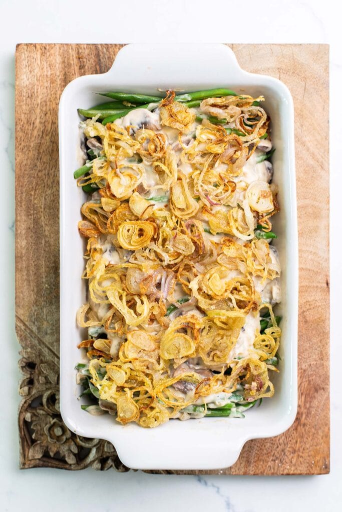 A casserole dish shown with green beans topped with crispy fried shallots.