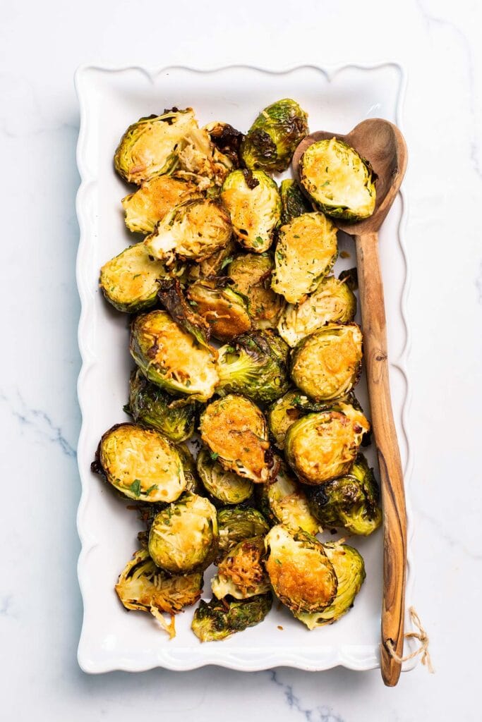 Crusted brussels sprouts shown on a white serving platter.