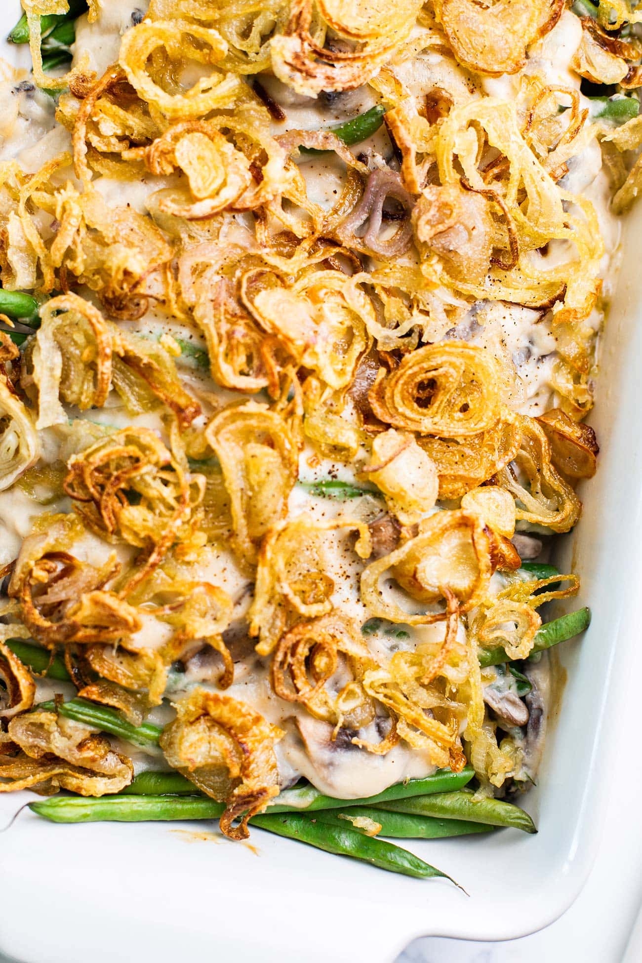 A green bean casserole topped with golden brown crispy shallots.