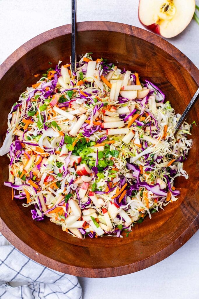 A crunchy apple slaw shown garnished with green onions.