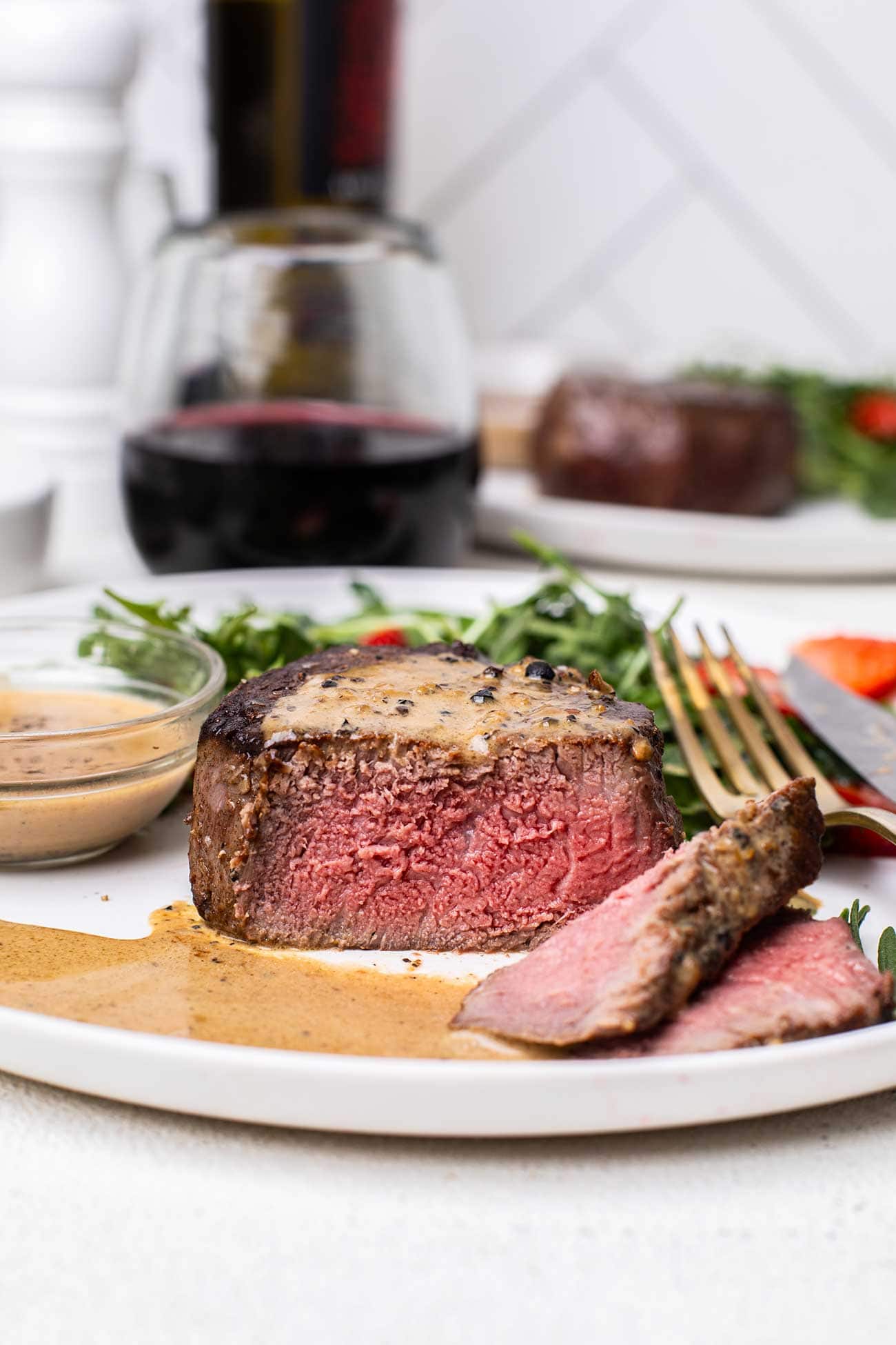 A filet mignon steak cooked to a perfect medium rare shown cut to show the pink center.