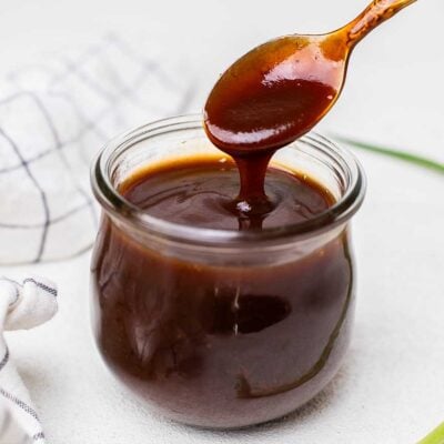 A thick honey bbq sauce shown in a jar next to a hand towel.