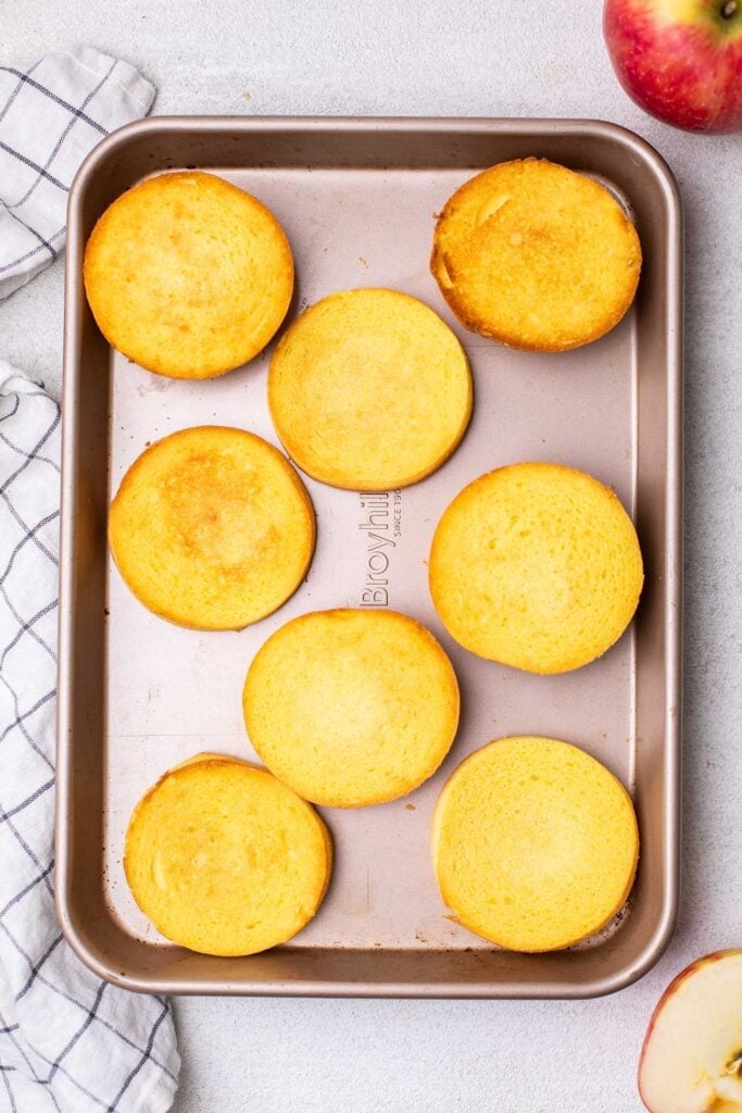 Gluten free buns shown on a baking sheet being toasted.