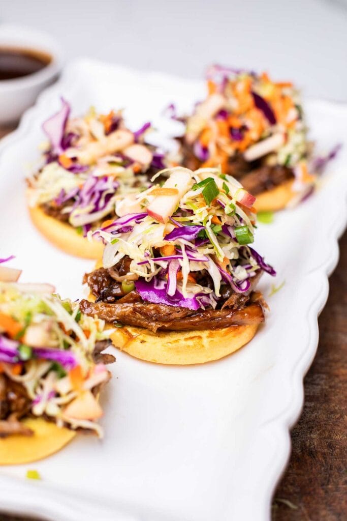 Buns shown topped with pulled pork and apple coleslaw.