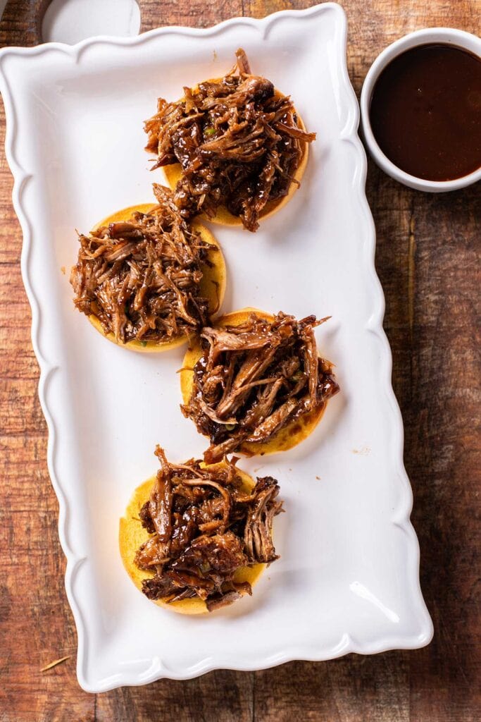 The bottoms of buns layered with a big scoop of bbq pulled pork.