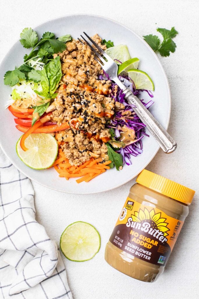 A spring roll salad sitting next to a jar of SunButter.