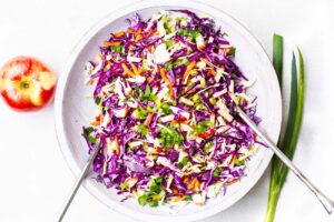 A colorful cabbage slaw made with apples and carrots.