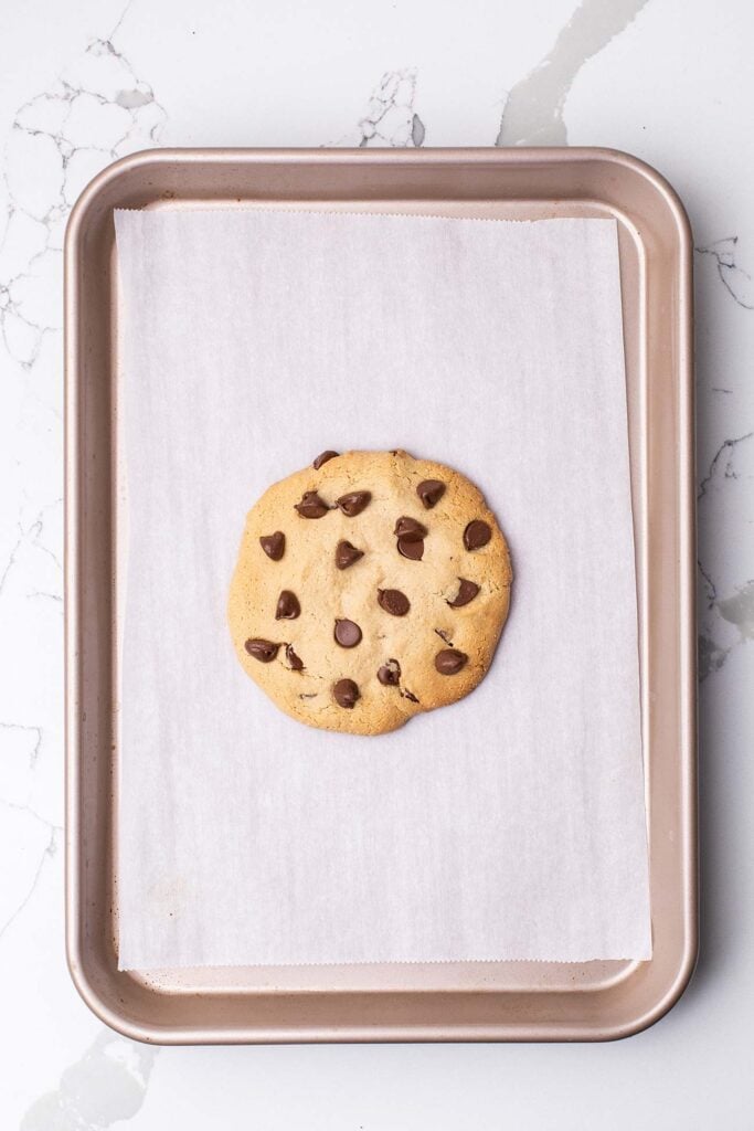 A baked cookie on a cookie sheet.