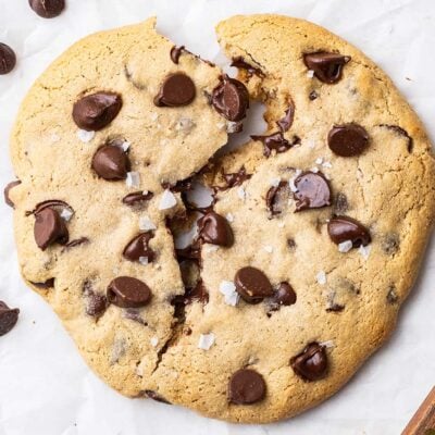 A chocolate chip protein cookie shown broken in half with melted chocolate chips.