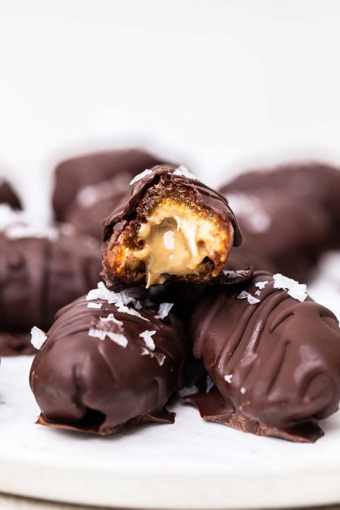 A chocolate date cut in half to show the nut butter filling.