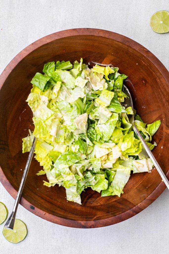 Romaine lettuce chopped in a bowl tossed with a creamy dressing.