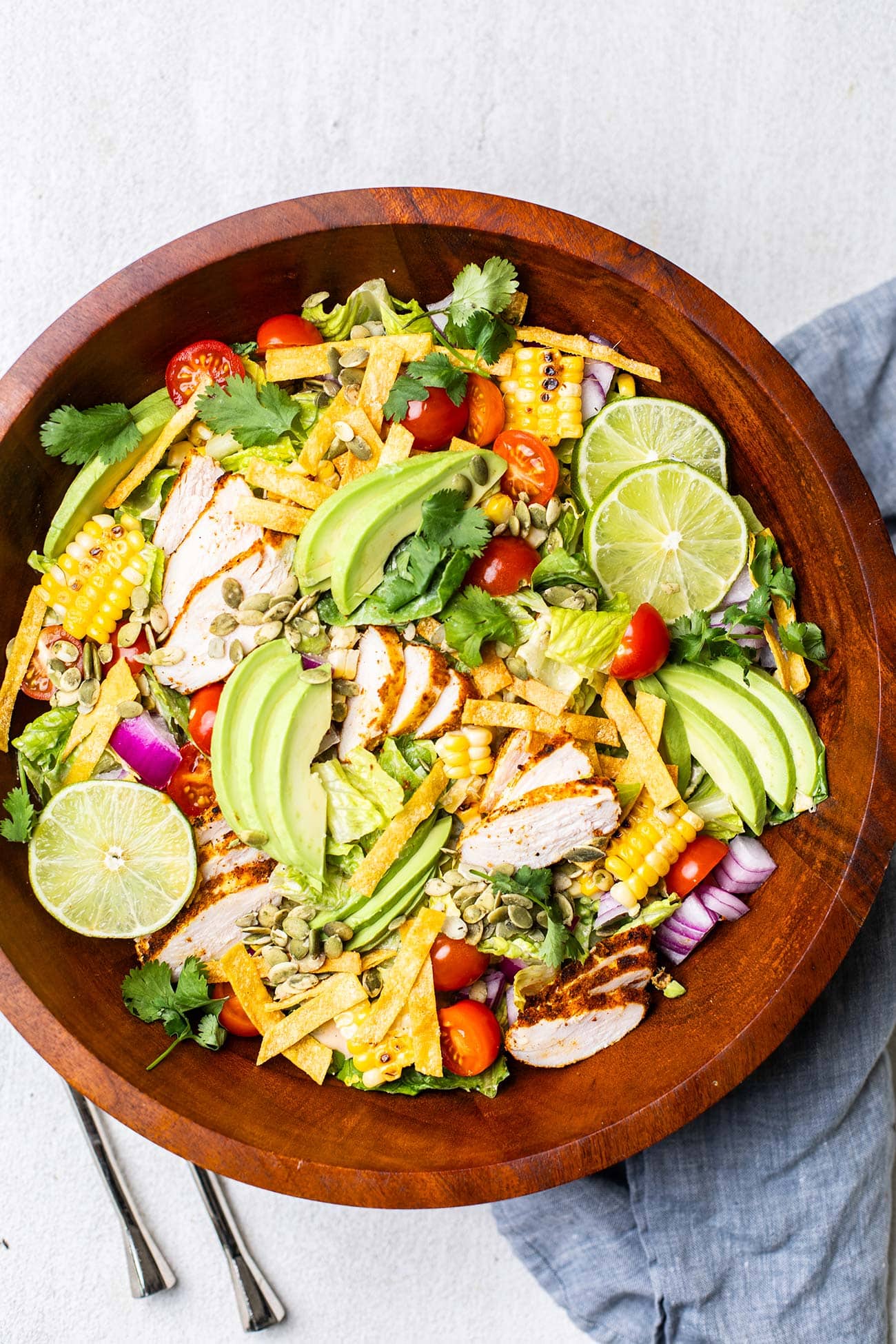 A Mexican chicken salad shown in a large wooden bowl.