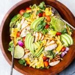 A vibrant Mexican Salad with Marinated chicken breast shown in a wooden bowl.
