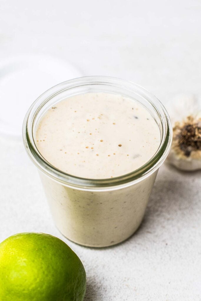 A creamy dressing in a clear glass jar.