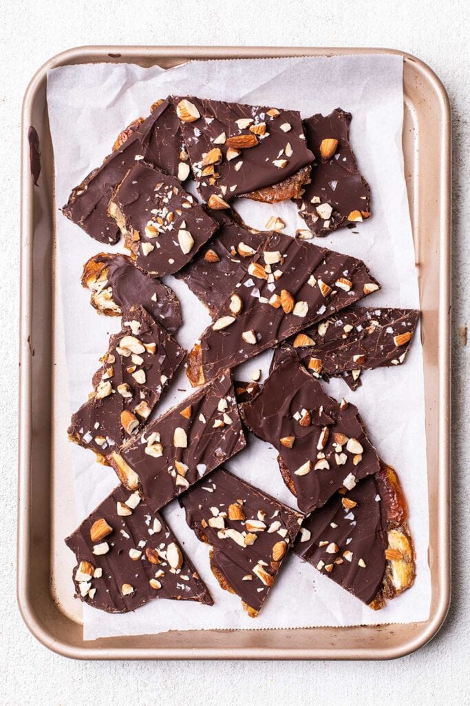 Date bark broken into pieces on a baking sheet.